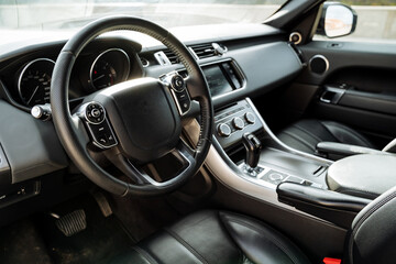 Leather car steering wheel, SUV dashboard, car interior, leather seat, natural trim materials, luxury transport interior.