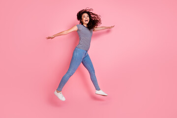 Full body length photo of careless girlfriend having fun flying in air wings arms enjoy active sports isolated over pink color background