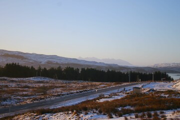 Blue sky over the road and snow-covered mountains