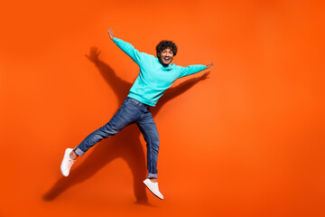 Full length photo of funky indian attractive guy flying air trampoline having fun in stylish...