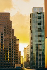 Fototapeta na wymiar Vertical aerial view of modern glass buildings against bright yellow sunset sky background in Austin