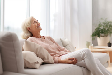 Cheerful sleepy blonde older lady lying on couch