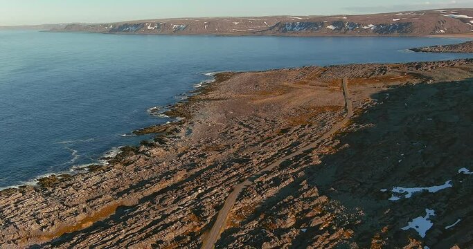 Aerial view of coast road 8100 to Hamningberg with rocky landscape in sunny summer weather, Varanger Peninsula, Norway.