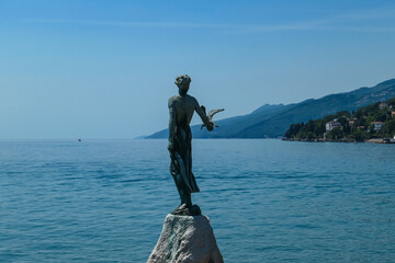 A close up on the Maiden with the Seagull statue, placed on the rocks in Opatija, Croatia. Calm...