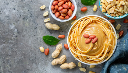 bowl of peanut butter and peanuts on table background top view with copy space creamy peanut pasta in small bowl - obrazy, fototapety, plakaty