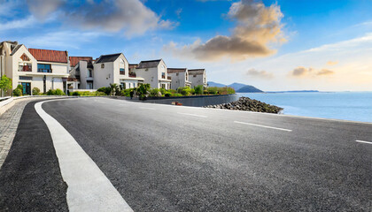 asphalt road and residential area buildings scenery by the sea