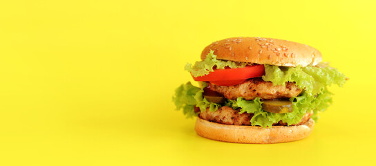 Cheeseburger on a yellow background. Juicy tasty burger on a bright background, side view. Fast...