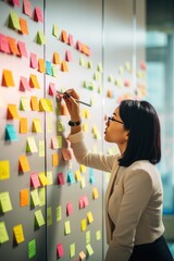Woman organizer attaches colorful sticky notes to white board. Life hack for easy memorization and...
