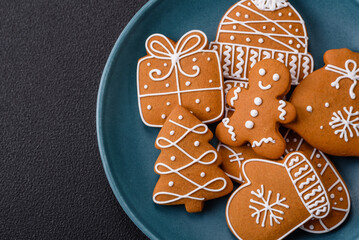 Beautiful Christmas gingerbread cookies of different colors on a ceramic plate