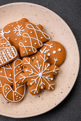 Beautiful Christmas gingerbread cookies of different colors on a ceramic plate