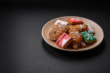 Beautiful Christmas gingerbread cookies of different colors on a ceramic plate