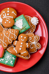 Beautiful Christmas gingerbread cookies of different colors on a ceramic plate