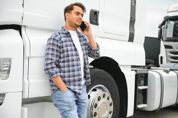 Indian truck driver tending a client on the phone.
