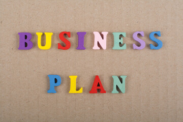 BUSINESS PLAN word on wooden background composed from colorful abc alphabet block wooden letters, copy space for ad text. Learning english concept.