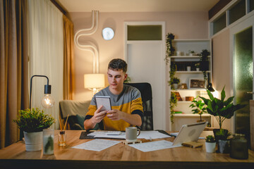 Young caucasian man teenager student study at home at the table night