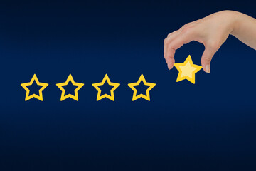 Woman's hand put the stars to complete five stars. Customer satisfaction concept. copy space and...
