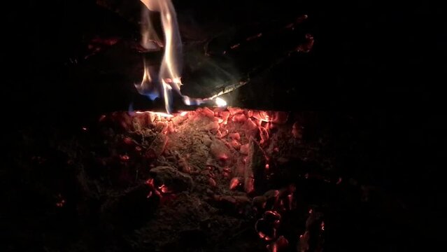 Closeup slow-motion footage of Coals in bonfire at night