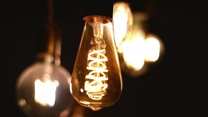 Retro LED light bulbs hanging on a dark background in interior. Electricity, Vintage