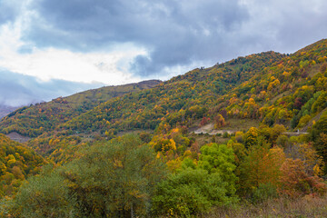 Naklejka premium Warm autumn in the mountains covered with bright autumn trees. Colorful landscape.