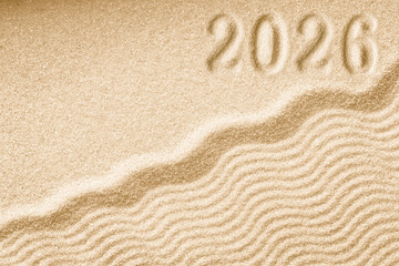 Fototapeta na wymiar Imprints of numbers 2026 new year on a golden sand waves