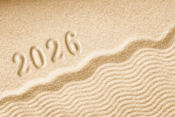 Imprints of numbers 2026 happy new year on a golden sand waves