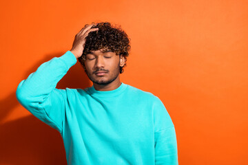 Photo of devastated person arm touch head closed eyes empty space isolated on orange color background