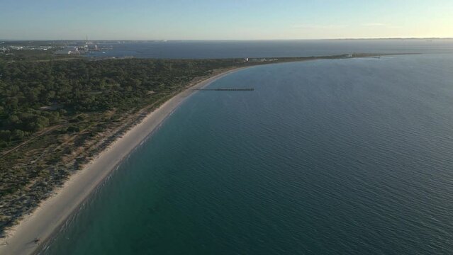 Drone view along the coastline before the blue skyline on a bright sunny day