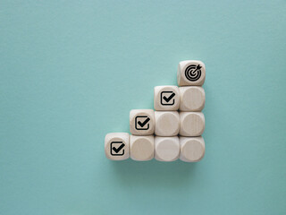 Corporate regulatory and compliance. Goals achievement and business success. Project and goals tracking. Task completion. Managing project timeline. Holding wooden cube with target achievement icon.