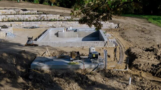 Construction site, construction of a swimming pool near a private house. Drone shot. 