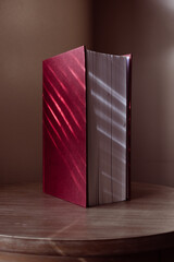 Red hardcover book standing vertically on a table