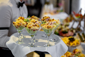 hands of a waiter prepare food for a buffet table in a restaurant