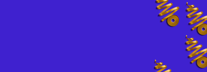 Obraz premium New Year banner with concept of Christmas trees made of golden ribbon on blue background. Top view