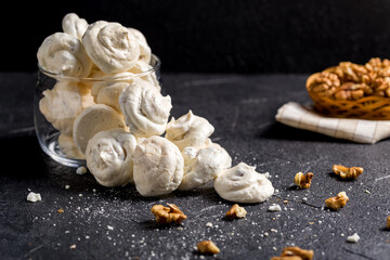 Small white meringues on a dark background