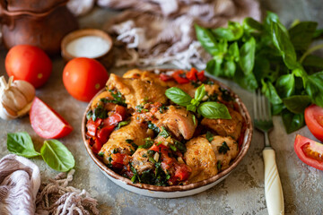 Baked chicken with vegetables and spices on a beautiful plate. Grilled chicken with vegetables for dinner for the whole family. View from above. Close-up.