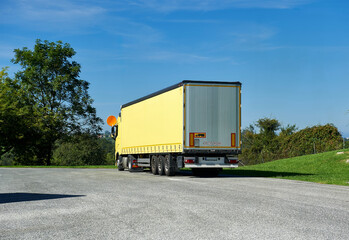 truck with yellow tarpaulin trailer parked in a service area