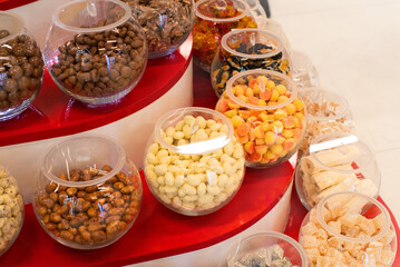 Glass jars with various bright sweets, gummy candies on the counter in a supermarket, soft focus