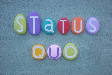 Status Quo, the state in which, latin phrase that is commonly used to indicate the same situation without changes, text composed with multi colored stone letters over green sand