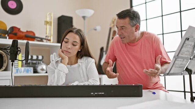 Upset male and female musicians looking distressed during piano practice in music studio