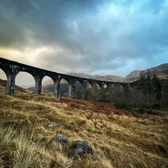 Foto op Plexiglas Glenfinnanviaduct Scenic shot of the Harry Potter bridge in Scotland under the gloomy stormy sky