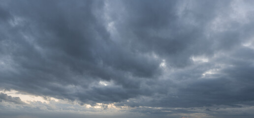 Panorama of a moody and wild cloudscape during blue hour after sunset