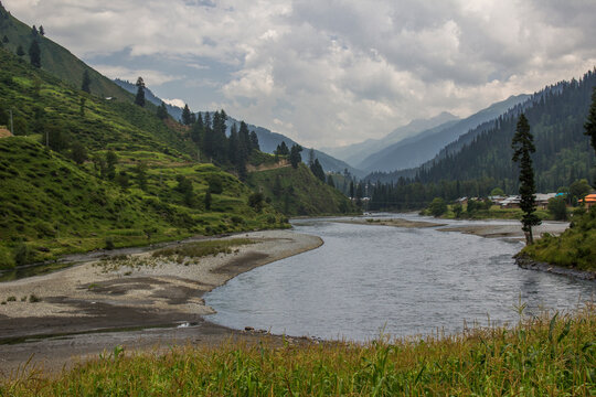 Picture of Mountain, Trees, River and Stream of adjoining areas of Kashmir. In this picture you can see the hill view along with stream and trees with beautiful scene of greenery on mountains