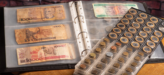 Money, collection of coins and Brazilian money notes, dark background, selective focus.