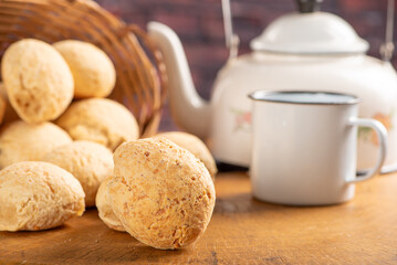 Cheese bread, basket with cheese bread arranged on rustic wood, dark background, selective focus.
