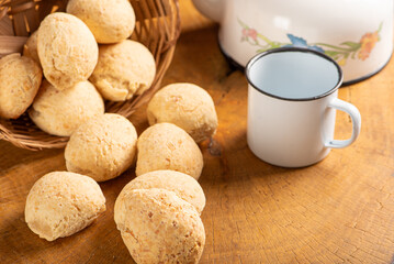 Cheese bread, basket with cheese bread arranged on rustic wood, dark background, selective focus.
