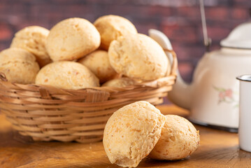 Cheese bread, basket with cheese bread arranged on rustic wood, dark background, selective focus.