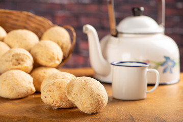 Cheese bread, basket with cheese bread arranged on rustic wood, dark background, selective focus.
