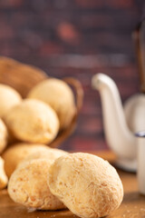 Cheese bread, basket with cheese bread arranged on rustic wood, dark background, selective focus.