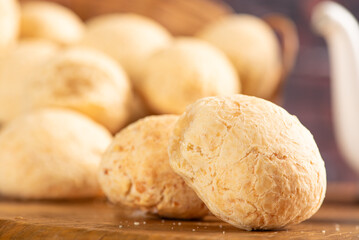 Cheese bread, basket with cheese bread arranged on rustic wood, dark background, selective focus.