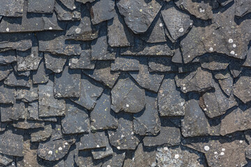 Detailed view of wall texture randomly lined with slate panels, typical and traditional shale stone...