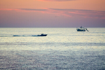 Naklejka premium fishing boats in the sea at dawn